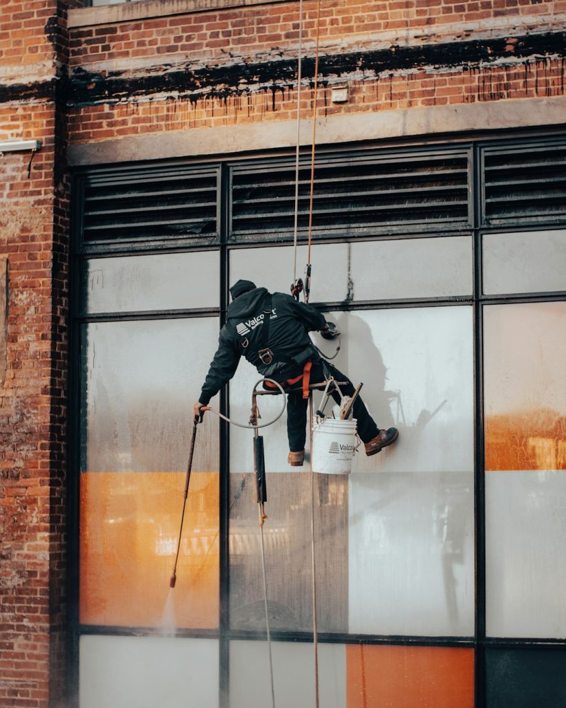 a-man-hanging-from-a-rope-on-the-side-of-a-building-kvuojdphbc0