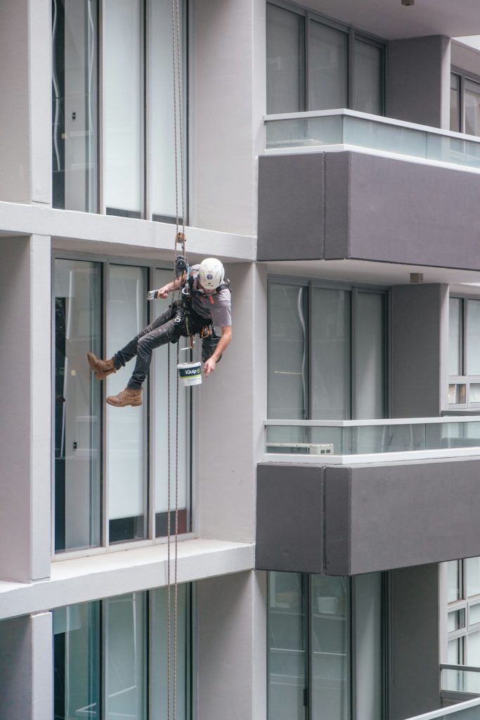 man-in-black-jacket-and-black-pants-jumping-on-window-during-daytime-qdldkmbmc6o